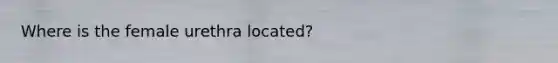 Where is the female urethra located?