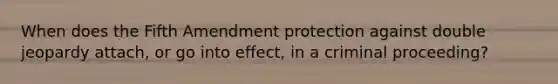 When does the Fifth Amendment protection against double jeopardy attach, or go into effect, in a criminal proceeding?