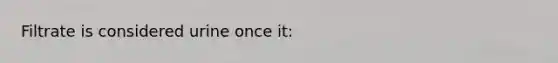 Filtrate is considered urine once it: