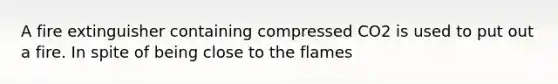 A fire extinguisher containing compressed CO2 is used to put out a fire. In spite of being close to the flames