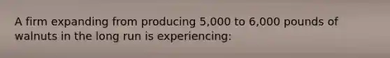 A firm expanding from producing 5,000 to 6,000 pounds of walnuts in the long run is experiencing: