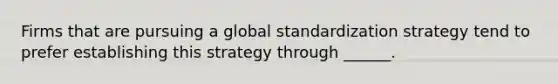 Firms that are pursuing a global standardization strategy tend to prefer establishing this strategy through ______.