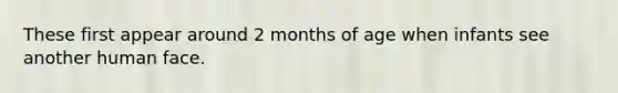 These first appear around 2 months of age when infants see another human face.