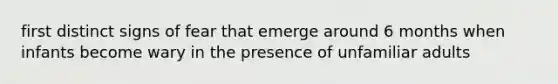 first distinct signs of fear that emerge around 6 months when infants become wary in the presence of unfamiliar adults