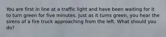 You are first in line at a traffic light and have been waiting for it to turn green for five minutes. Just as it turns green, you hear the sirens of a fire truck approaching from the left. What should you do?