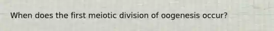 When does the first meiotic division of oogenesis occur?
