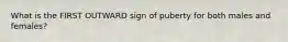 What is the FIRST OUTWARD sign of puberty for both males and females?