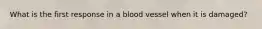 What is the first response in a blood vessel when it is damaged?