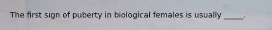 The first sign of puberty in biological females is usually _____.