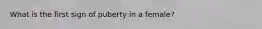 What is the first sign of puberty in a female?