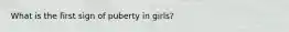What is the first sign of puberty in girls?