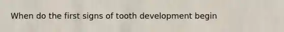 When do the first signs of tooth development begin