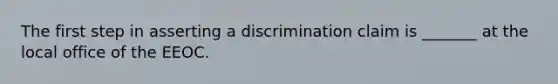 The first step in asserting a discrimination claim is _______ at the local office of the EEOC.