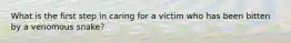 What is the first step in caring for a victim who has been bitten by a venomous snake?