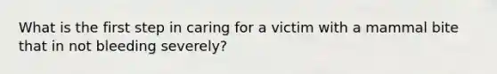 What is the first step in caring for a victim with a mammal bite that in not bleeding severely?