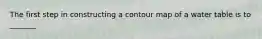 The first step in constructing a contour map of a water table is to _______