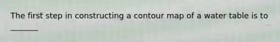 The first step in constructing a contour map of a water table is to _______