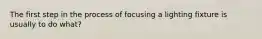 The first step in the process of focusing a lighting fixture is usually to do what?