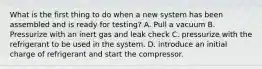 What is the first thing to do when a new system has been assembled and is ready for testing? A. Pull a vacuum B. Pressurize with an inert gas and leak check C. pressurize with the refrigerant to be used in the system. D. introduce an initial charge of refrigerant and start the compressor.