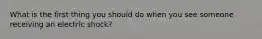 What is the first thing you should do when you see someone receiving an electric shock?