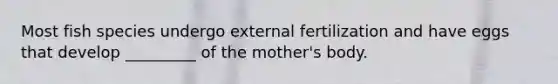 Most fish species undergo external fertilization and have eggs that develop _________ of the mother's body.