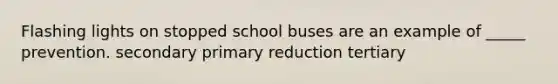 Flashing lights on stopped school buses are an example of _____ prevention. secondary primary reduction tertiary