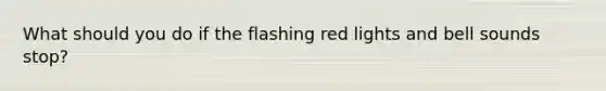 What should you do if the flashing red lights and bell sounds stop?