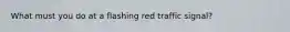 What must you do at a flashing red traffic signal?