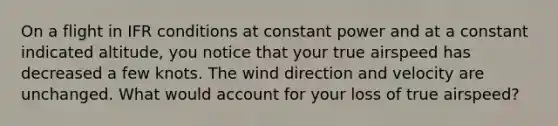 On a flight in IFR conditions at constant power and at a constant indicated altitude, you notice that your true airspeed has decreased a few knots. The wind direction and velocity are unchanged. What would account for your loss of true airspeed?