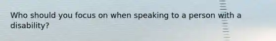 Who should you focus on when speaking to a person with a disability?