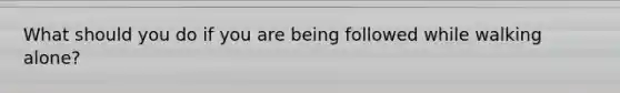 What should you do if you are being followed while walking alone?