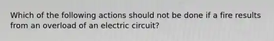 Which of the following actions should not be done if a fire results from an overload of an electric circuit?