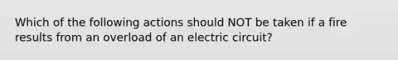 Which of the following actions should NOT be taken if a fire results from an overload of an electric circuit?