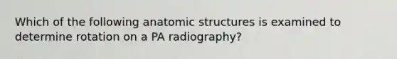 Which of the following anatomic structures is examined to determine rotation on a PA radiography?