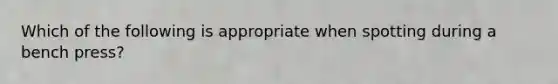 Which of the following is appropriate when spotting during a bench press?