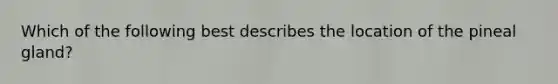 Which of the following best describes the location of the pineal gland?