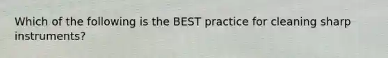 Which of the following is the BEST practice for cleaning sharp instruments?