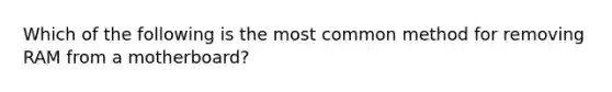 Which of the following is the most common method for removing RAM from a motherboard?