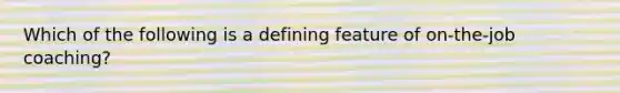 Which of the following is a defining feature of on-the-job coaching?