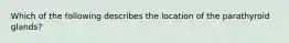 Which of the following describes the location of the parathyroid glands?