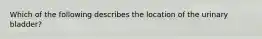 Which of the following describes the location of the urinary bladder?