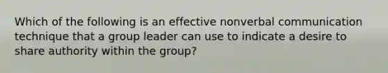 Which of the following is an effective nonverbal communication technique that a group leader can use to indicate a desire to share authority within the group?