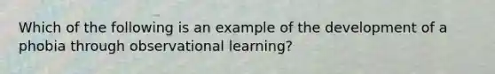 Which of the following is an example of the development of a phobia through observational learning?