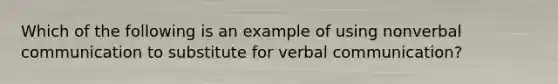Which of the following is an example of using nonverbal communication to substitute for verbal communication?