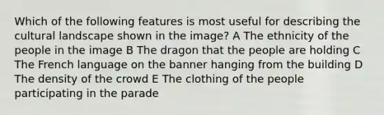 Which of the following features is most useful for describing the cultural landscape shown in the image? A The ethnicity of the people in the image B The dragon that the people are holding C The French language on the banner hanging from the building D The density of the crowd E The clothing of the people participating in the parade