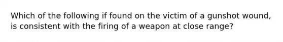 Which of the following if found on the victim of a gunshot wound, is consistent with the firing of a weapon at close range?