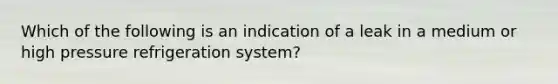 Which of the following is an indication of a leak in a medium or high pressure refrigeration system?