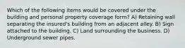 Which of the following items would be covered under the building and personal property coverage form? A) Retaining wall separating the insured's building from an adjacent alley. B) Sign attached to the building. C) Land surrounding the business. D) Underground sewer pipes.