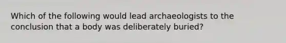 Which of the following would lead archaeologists to the conclusion that a body was deliberately buried?