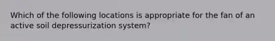 Which of the following locations is appropriate for the fan of an active soil depressurization system?